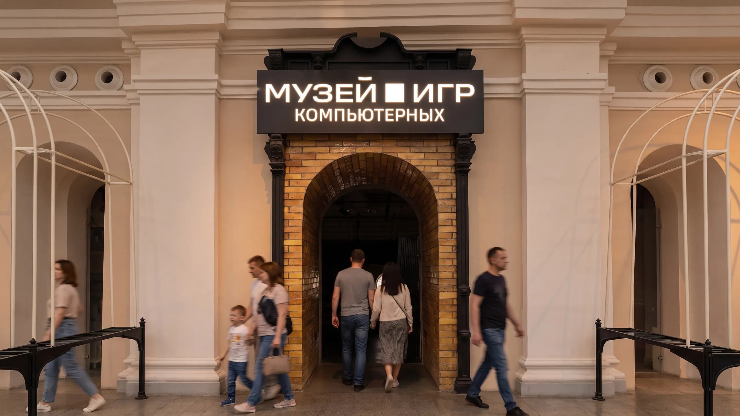 The entrance to the Museum of Computer Games in Vokzal 1853: a brick arch with the museum sign, visitors walking in.